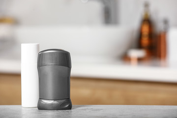 Different deodorants on table in bathroom, space for text