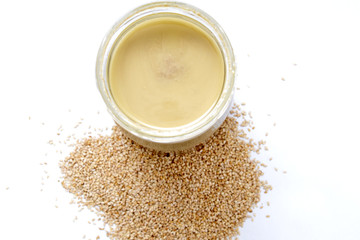 tahini syrup in jar on white background