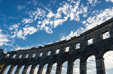 Fototapeta na wymiar Arched walls with the blue sky of Pula Arena (Arena di Pola), Roman amphitheatre with the blue sky on background in Pula, Croatia - Image