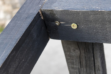 Screw in wood, two screws screwed in the black wood, wood plank with screws close up - Image