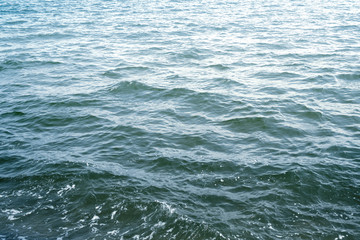 Water surface with ripples and sunlight reflections