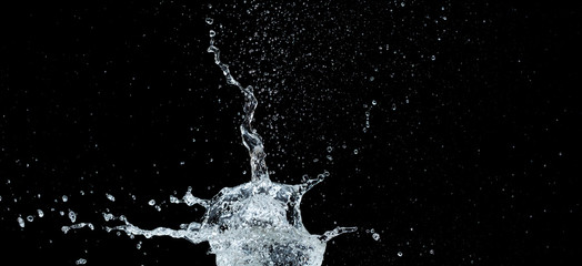 Obraz na płótnie Canvas High-speed shot of a water balloon bursting on black background.