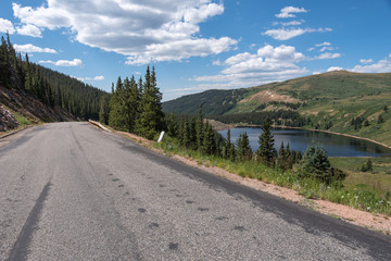 Fototapeta na wymiar Guanella Pass in Colorado landscape of road, trees and lake below mountains