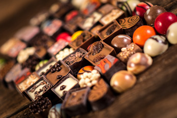 Assorted chocolate pralines on the wooden background