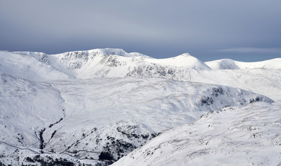 A winter snowy Lake District scene of Helvellyn, Striding Edge and Catstye Cam from Rampsgill Head near Hartsop.