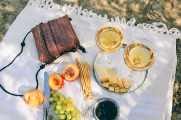 Two glasses of the white wine and tasty food and accessories  Summer picnic in the beach