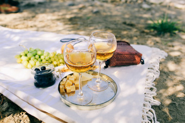 Two glasses of the white wine and tasty food and accessories  Summer picnic in the beach