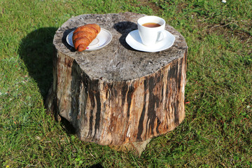 Woman in the summer has breakfast in a summer