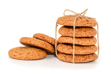 Homemade cookies. Five sweet cookie made from oatmeal flour, stacked and tied with linen rope in rustic style and three next. Tasty biscuit in high resolution closeup isolated on white background.
