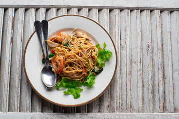 Spaghetti seafood with chili & basil on old Wood Background. close up