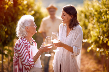 family in vineyard tasting wine. - Powered by Adobe