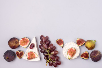 Brie Cheese Ripe Cut Figs Ripe Grape are Lying on Blue Background Food Background with Cheese and AutumnFruits Copy Space Horizontal