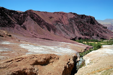 Red, magenta mountain scenery in the Kalu Valley between Kabul and Bamyan (Bamiyan), Afghanistan. Taken from the road on the southern route between Kabul and Bamyan (Bamiyan) in central Afghanistan.