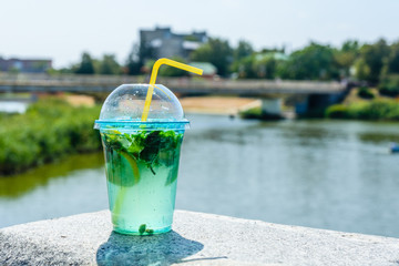 Mojito cocktail on a granite parapet with river on background