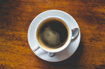 Top view hot black coffee on grunge wood table