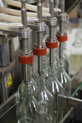 close up machines filling fresh water to glass bottles