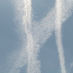 Three width condensation trails, also called vapour trails or contrails, of aircrafts in the sky.