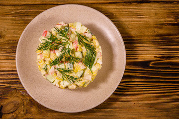 Salad with crab sticks, boiled eggs and cucumbers on a ceramic plate. Top view