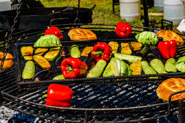 Different vegetables cooking on a grill at country fair