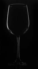 Glass of wine on a black background, standing on a black stand with reflection