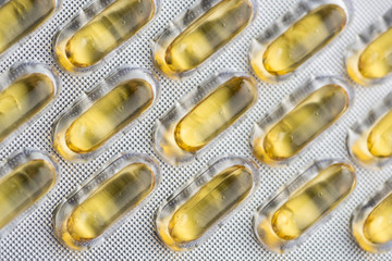 yellow oval long capsules with medicine in a blister