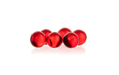 transparent white and red round small capsules with medicine on a black and white background