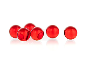 transparent white and red round small capsules with medicine on a black and white background