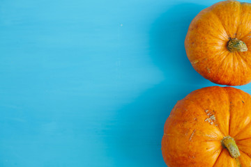 Pumpkins on blue wooden background Thanksgiving and Halloween concept. View from above. Top view....