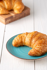 Flacky crispy fresh croissant rolls with blue background