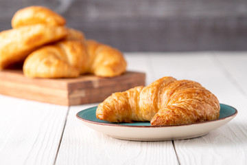 Flacky crispy fresh croissant rolls with blue background
