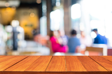 Wood table top on blur people in coffee shop background