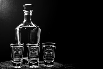 Drink bottle and glass with alcohol content. Image of translucent skull in glass. Alcoholism,...