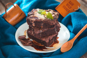 Chocolate brownies stacks on wooden background, homemade sweet and dessert