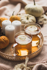 autumn cosy pumpkin, candles and autumn plants on window with led lights bokeh