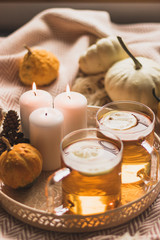 Obraz na płótnie Canvas autumn cosy pumpkin, candles and autumn plants on window with led lights bokeh
