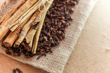 cloves and cinnamon on burlap sacks and wood