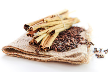 cloves and cinnamon on burlap sacks isolated white