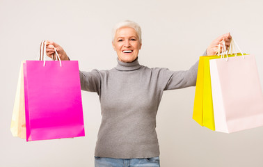 Happy Elderly Woman Posing With Colorful Shopping Bags