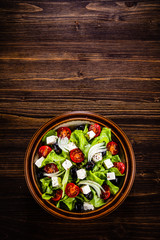 Obraz na płótnie Canvas Greek salad in bowl on wooden table