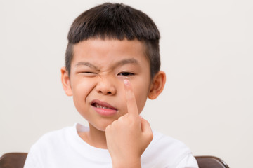 Asian boy look at contact lens