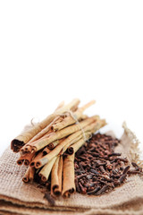 cloves and cinnamon on burlap sacks isolated white
