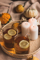 autumn cosy pumpkin, candles and autumn plants on window with led lights bokeh