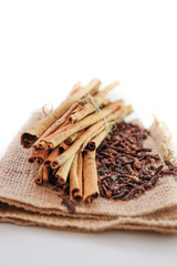 cloves and cinnamon on burlap sacks isolated white