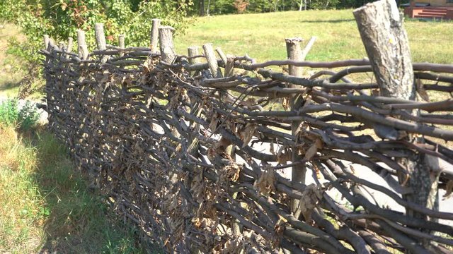 Old wooden fence made of tree branches.