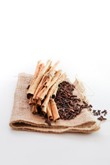 cloves and cinnamon on burlap sacks isolated white