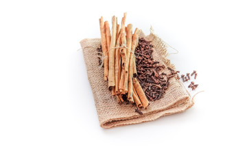 cloves and cinnamon on burlap sacks isolated white