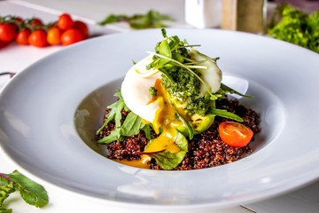 Quinoa with avocado, poached egg and microgreen in a white plate, horizontal orientation