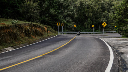 Motociclista menejando en curvas dentro del bosque