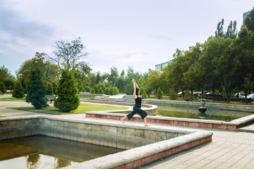 young girl in the park is doing yoga asana