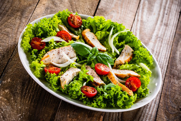 Caesar salad on white plate on wooden table